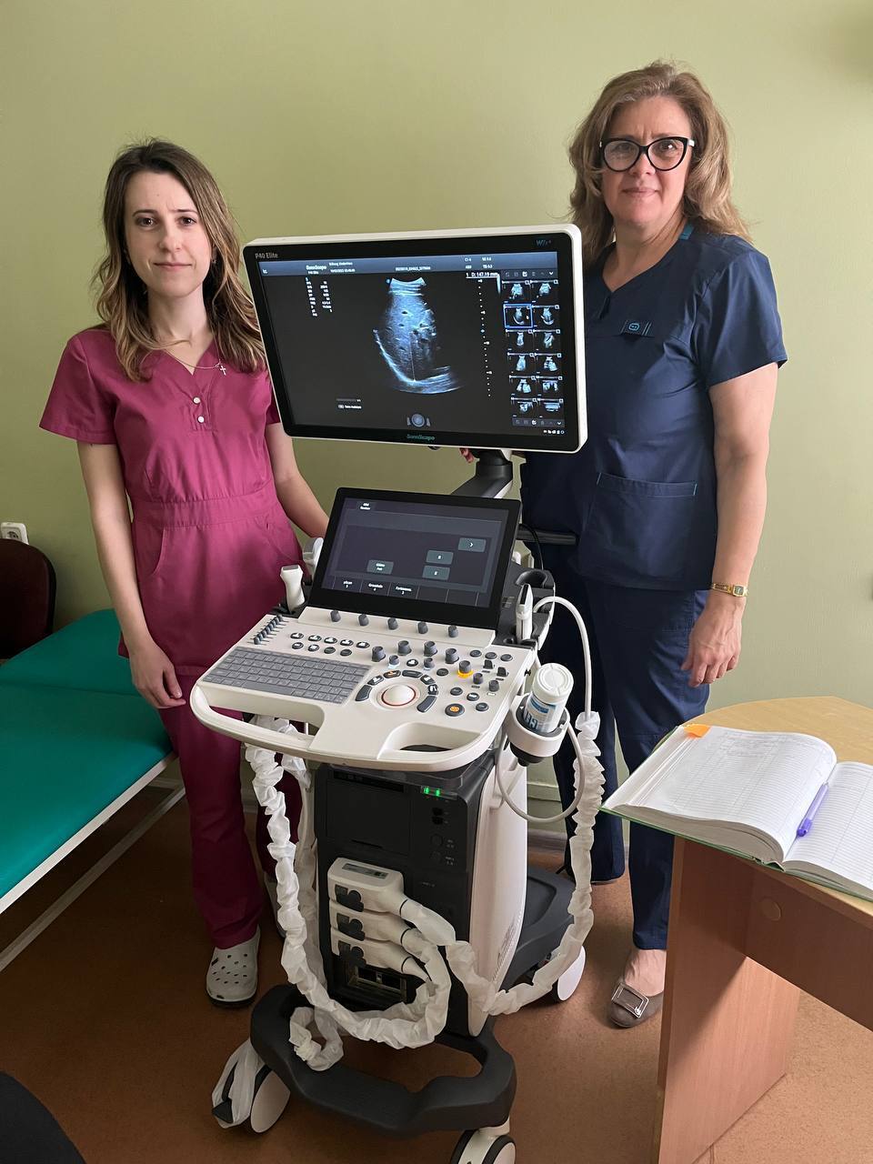Zwei Mitarbeiterinnen der Kinderklinik in Kiew stehen neben einem neuen Ultraschallgerät, das Teil der Hilfslieferung der Stiftung KinderHerz ist. 